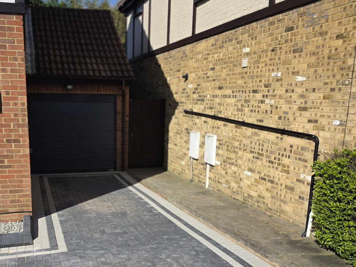Charcoal block paving laid in herringbone with a lighter border course