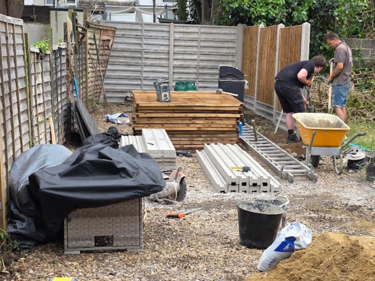 Closeboard fencing being installed along a garden boundary