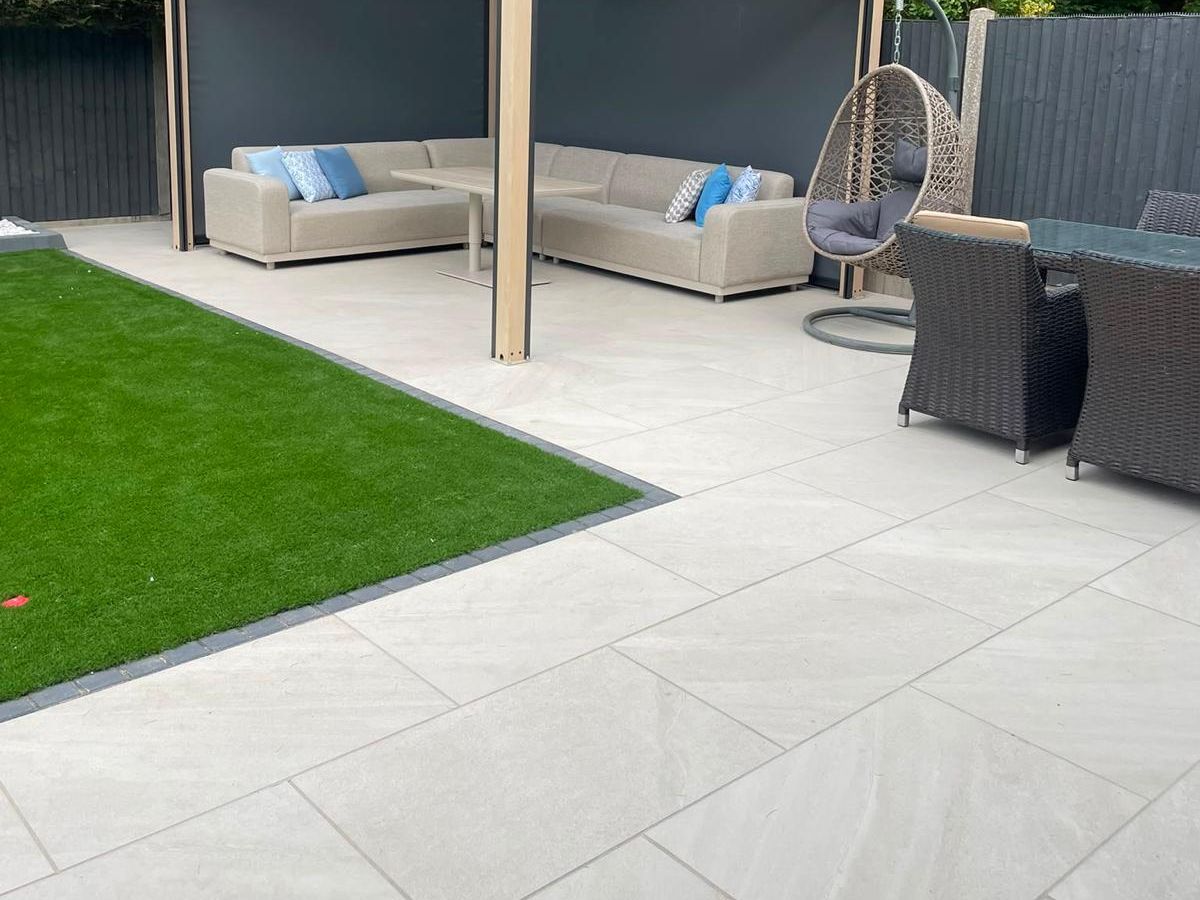 Porcelain paved patio with a garden room and outdoor seating