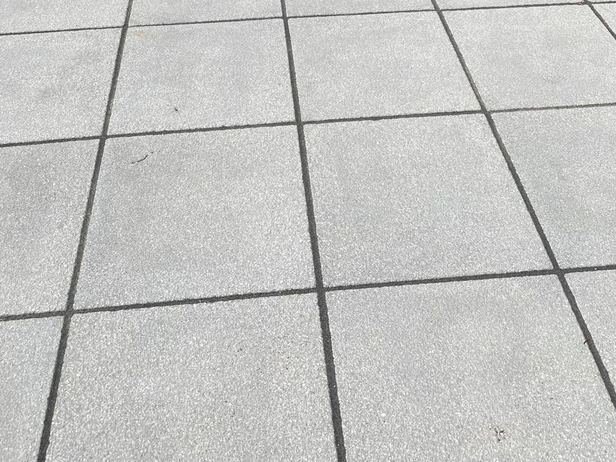 Porcelain paving and a sleeper-edged step between patio and lawn