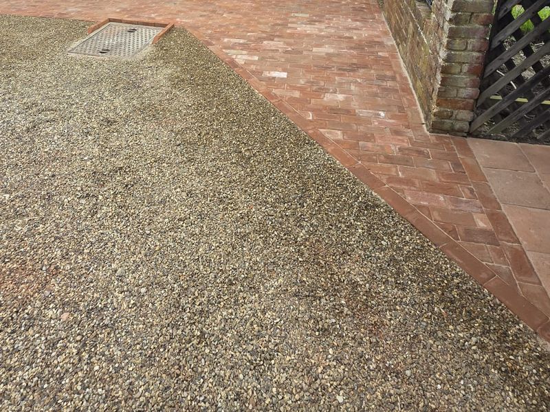 A resin bound driveway in a fine bonded aggregate, edged with clay pavers